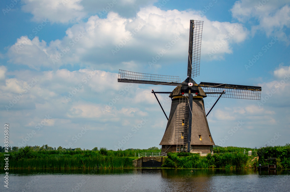Rural scene in the Netherlands with a traditional Dutch windmill near the canal at Kinderdijk