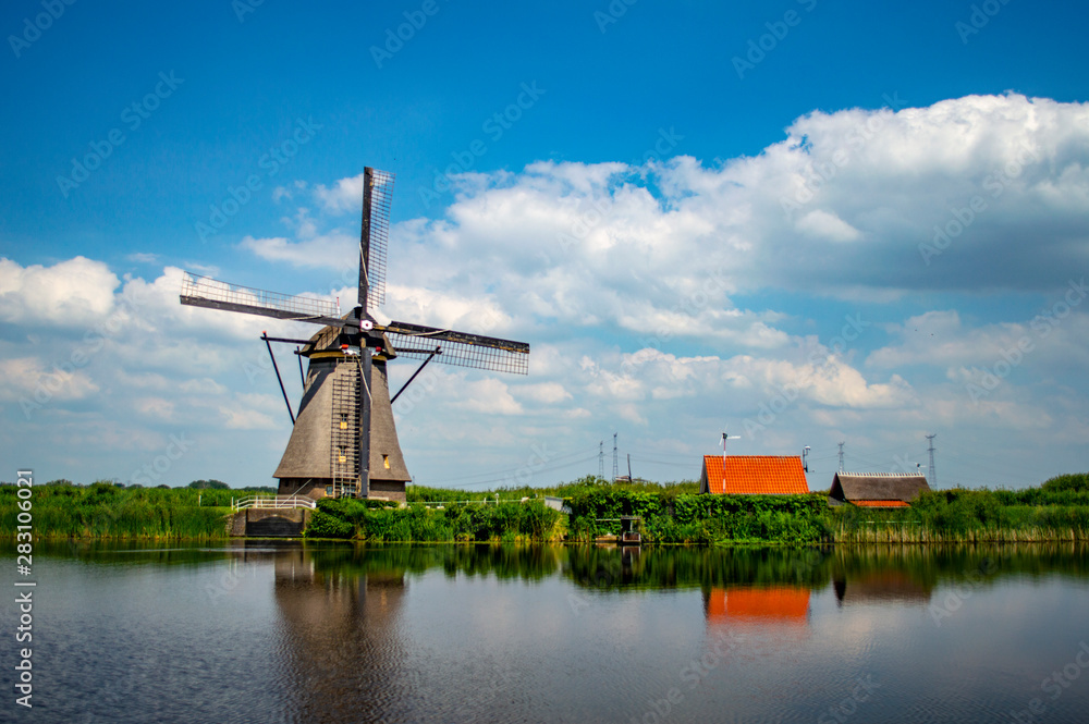 Rural scene with traditional Dutch windmill and houses at Kinderdijk, Netherlands.