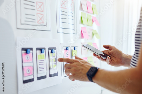 Obraz na płótnie Web developer with mobile phone planning website ux app development on white board