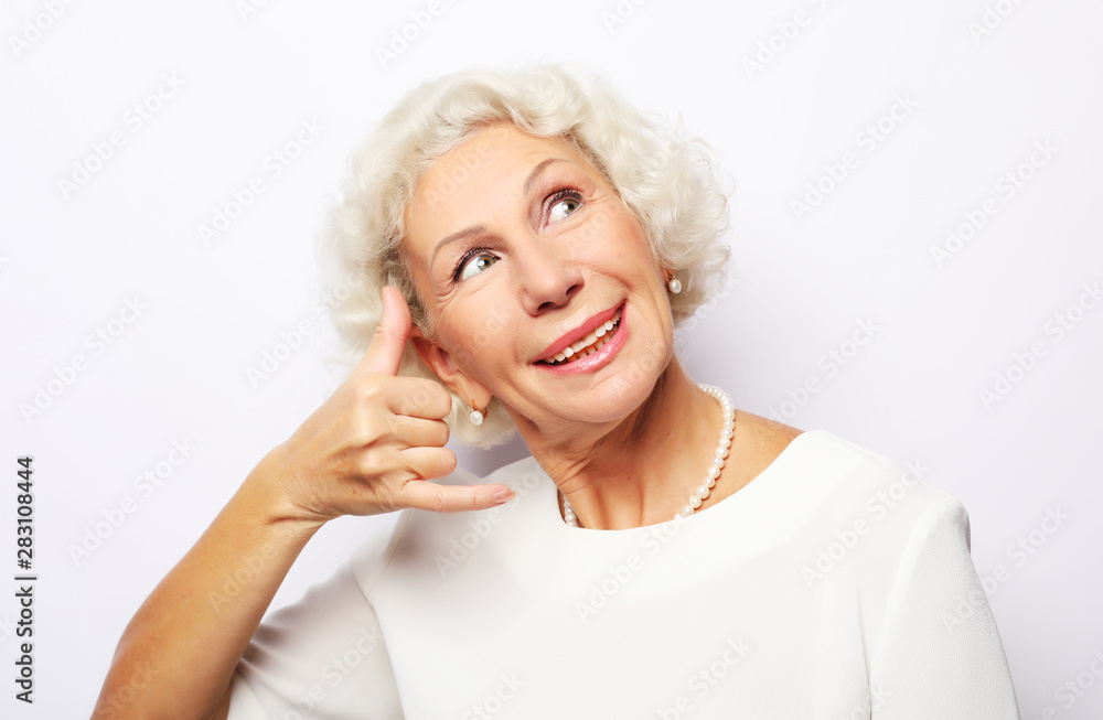 Call me, please! Lifestyle, emotion and people concept: Elderly happy woman is gesturing to call her with a hand