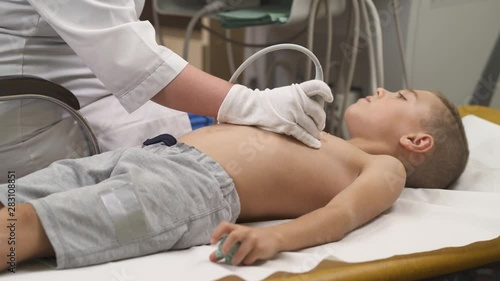 A side view of a professional female sonographer providing thoracic ultrasound examination. Ultrasound scanning. Healthcare concept photo