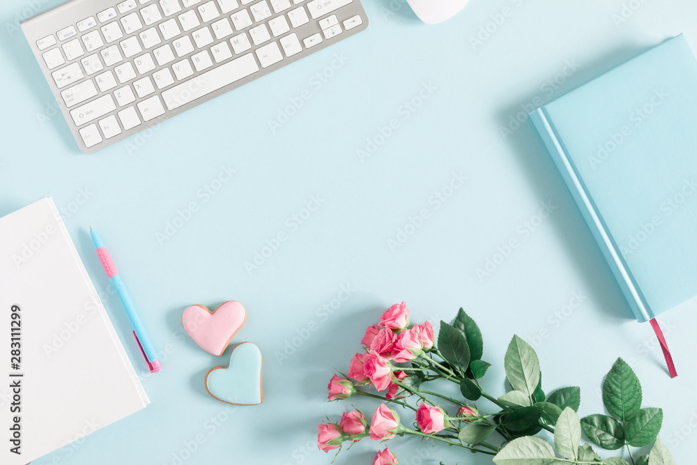 Composition Valentine's Day. Keyboard, notepad, rose flowers, ginger cookie in shape heart on pastel blue background. Valentine day concept, design. Flat lay, top view, copy space Composition Valentine's Day. Keyboard, notepad, rose flowers, ginger cookie in shape heart on pastel blue background. Valentine day concept, design. Flat lay, top view, copy space
