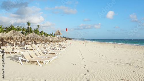 Holidays on the Maldives sandy beach. Beach umbrellas and deck chairs on white sand. Sunny summer day in the Atlantic Ocean. Travel to tropical paradise. Walk along the sea coast.