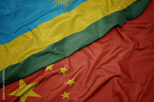 waving colorful flag of china and national flag of rwanda.