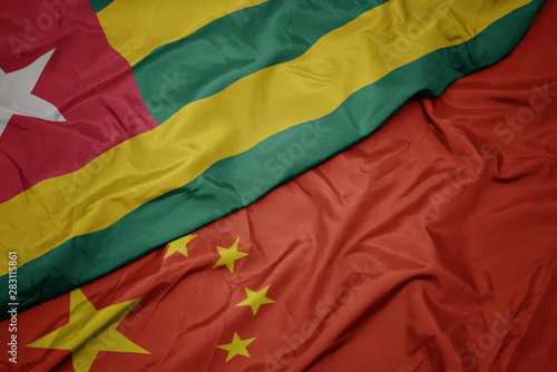 waving colorful flag of china and national flag of togo.