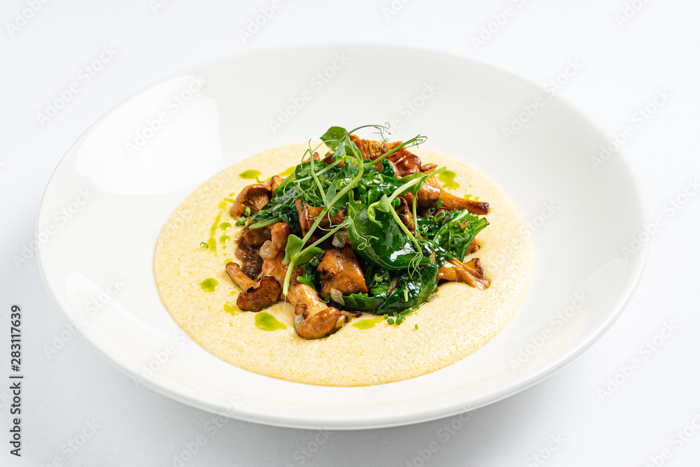 polenta with chanterelles on the white plate polenta with chanterelles on the white plate