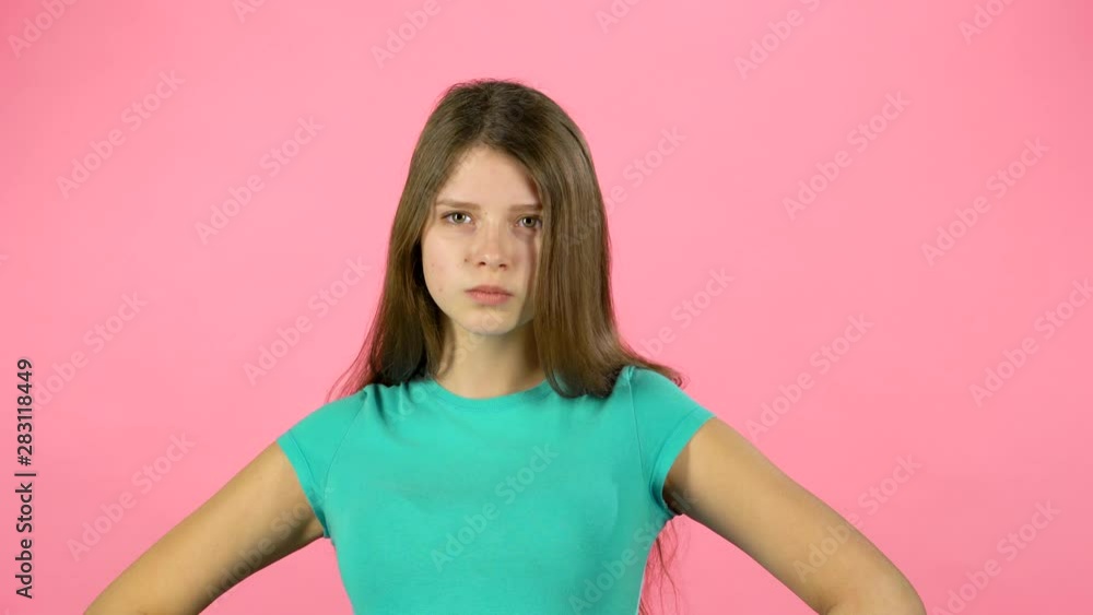 Little female is angry and unsatisfied on pink background. Little female is angry and unsatisfied on pink background.