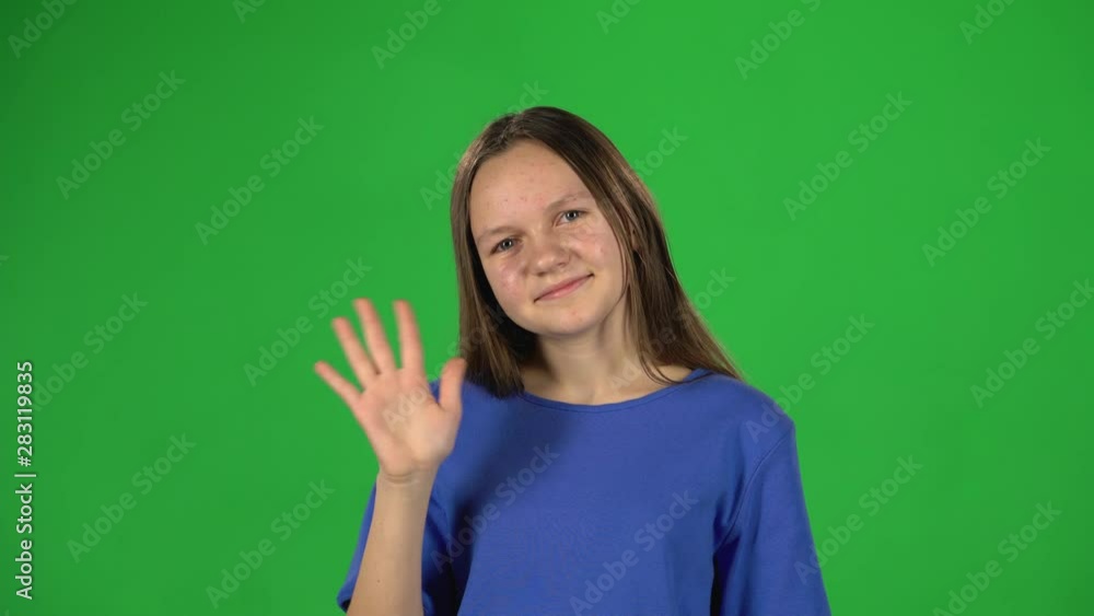 Girl is waving hello and inviting to come her on green background Girl is waving hello and inviting to come her on green background