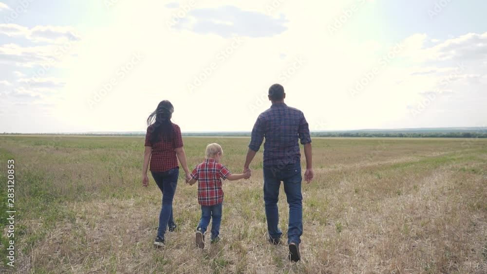 happy family teamwork friendship care concept slow motion video. father mom and son walk in nature sunset sunlight hold hand. happy family parents man and girl hold little boy walking hand outdoors in happy family teamwork friendship care concept slow motion video. father mom and son walk in nature sunset sunlight hold hand. happy family parents man and girl hold little boy walking hand outdoors in
