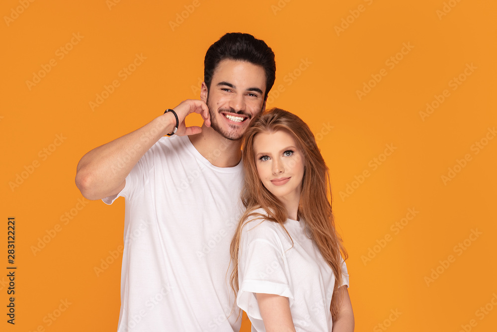 Happy youg couple posing together in studio. Happy youg couple posing together in studio.