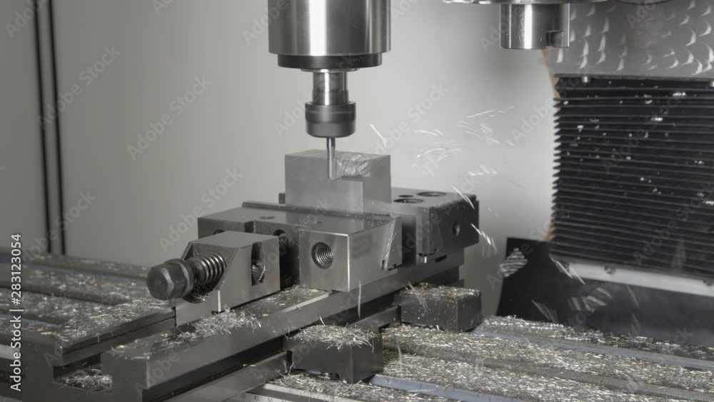 SLOW MOTION, CLOSE UP: Shiny shavings fly off a piece of aluminium being processed by a CNC drill. Conventional fine end mill drill cutting and shaving a piece of metal into an unfinished product. SLOW MOTION, CLOSE UP: Shiny shavings fly off a piece of aluminium being processed by a CNC drill. Conventional fine end mill drill cutting and shaving a piece of metal into an unfinished product.