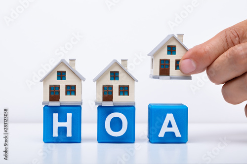 Businessman Placing House Models On HOA Cubic Blocks photo