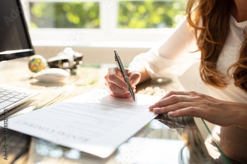 Businesswoman's Hand Signing Contract With Pen photo