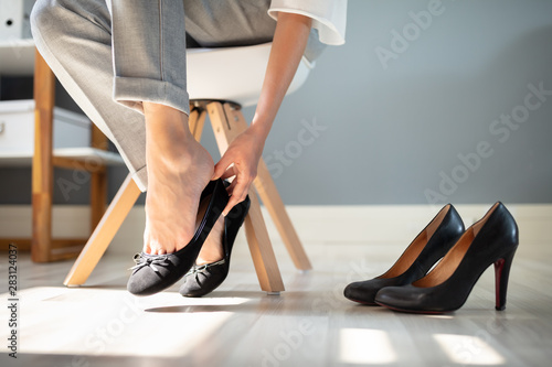 Businesswoman Changing Shoes In Office