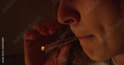 A man inhales from a joint - extreme closeup - slow motion - shot on RED