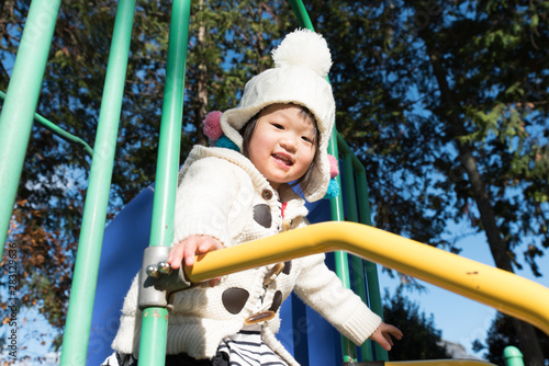 Fototapeta Naklejka Na Ścianę i Meble -  Japanese girl slides on the park slide