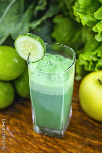 Green smoothie on dark wood background. Healthy smoothie herbal cocktail. Green fruits and vegetables. Healthy food and diet concept.