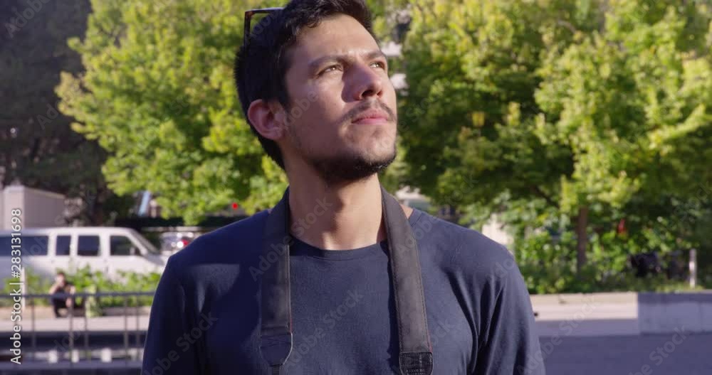 Young man walks forward while holding a camera outdoors - slow motion - shot on RED Young man walks forward while holding a camera outdoors - slow motion - shot on RED