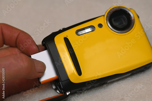 Hand inserting batterinto camera