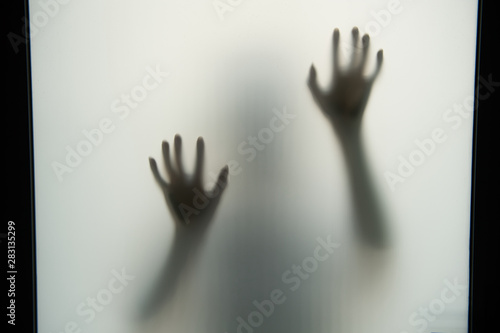 The dark shadow of the hands and body behind the opaque glass makes it look scary in the Halloween concept.