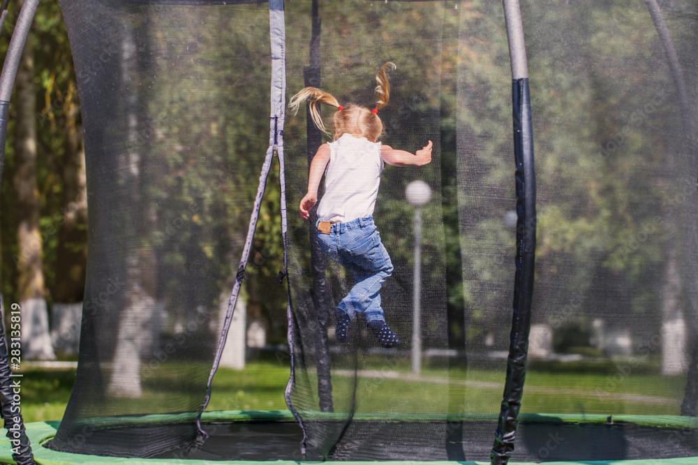 girl jumping on trampoline in park girl jumping on trampoline in park