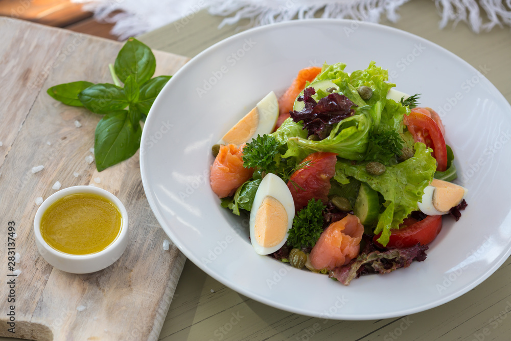 Vegetable salad with egg and salmon served with basil and topping sauce Vegetable salad with egg and salmon served with basil and topping sauce