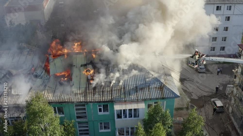 firefighters extinguish a fire on the roof of a residential highrise building. top view