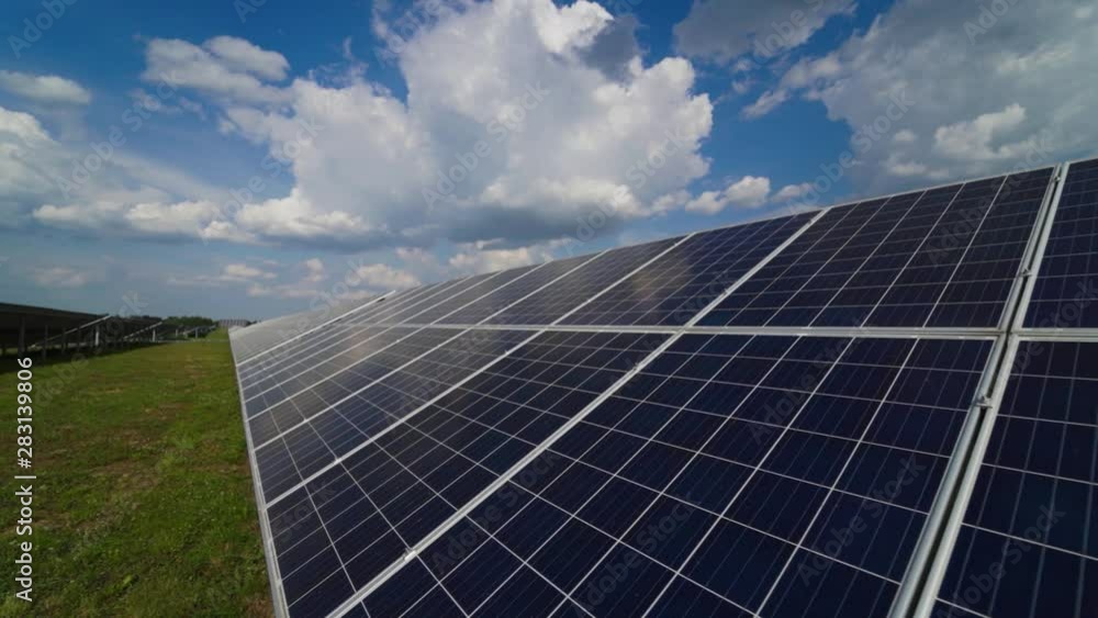 Solar panels on a modern electrical station. The clouds are reflected on the surface of the solar panels. Alternative clean electricity. Solar panels on a modern electrical station. The clouds are reflected on the surface of the solar panels. Alternative clean electricity.