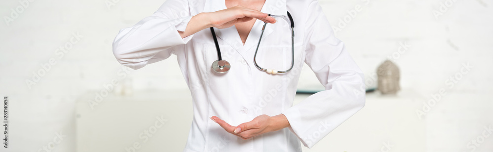 panoramic shot of doctor in white coat with stethoscope gesturing in clinic panoramic shot of doctor in white coat with stethoscope gesturing in clinic