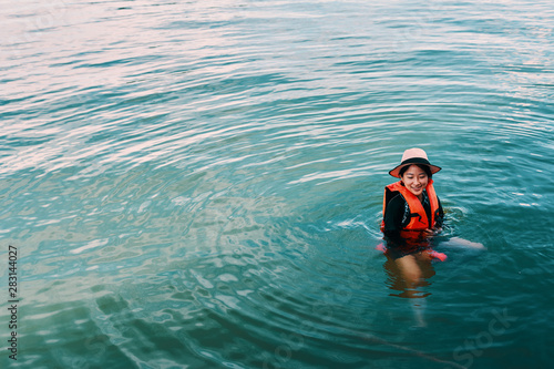 Asian woman is floating on water © tuckraider