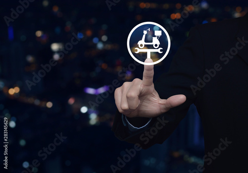 Businessman pressing service fix motorcycle with wrench tool flat icon over blur colorful night light city tower and skyscraper, Business repair motorbike service concept