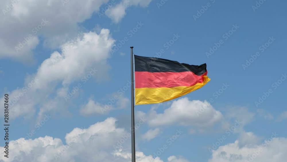German flag, national flag of Germany waving on flagpole blue sky background German flag, national flag of Germany waving on flagpole blue sky background