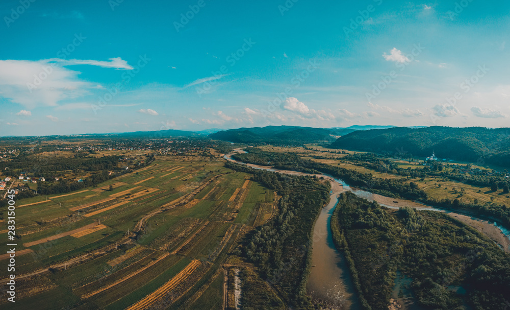Rural landscape in the low mountains of the Western Carpathians, visible mountain river and fields.