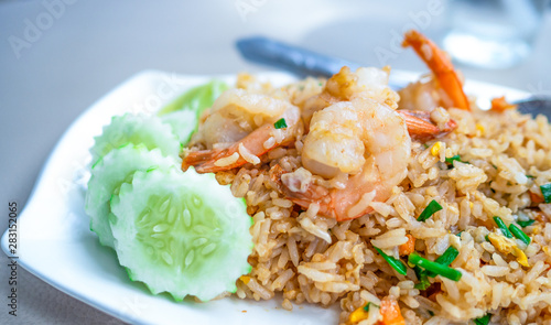 Thai food, Shrimp fried rice In a white plate ready Vegetables placed in the dish.