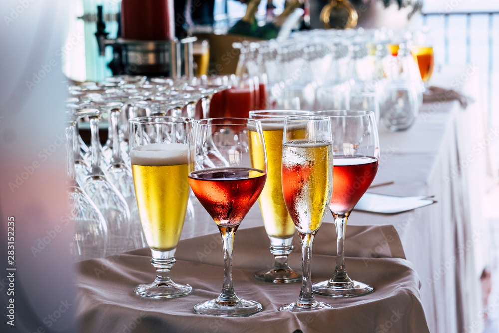 Set of coloured glasses at the restaurant with wines and. beer - concept. of celebration and catering work - defocused background with bar Set of coloured glasses at the restaurant with wines and. beer - concept. of celebration and catering work - defocused background with bar