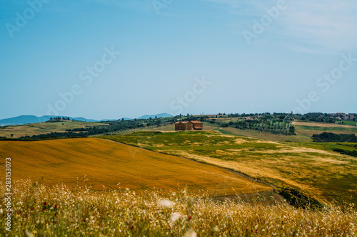 Tuscany rural sunset landscape. Countryside farm, cypresses trees, fields, sun light and cloud. Italy. Agro tour of Europe. Holiday outdoor vacation trip.