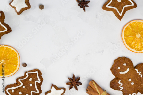 Frame from spices, Christmas cookies, gingerbread man, oranges on white concrete background. Recipe, invitation concept. Top view, flat lay, close-up, copy space, layout design