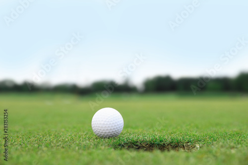 Golf ball near hole on green course