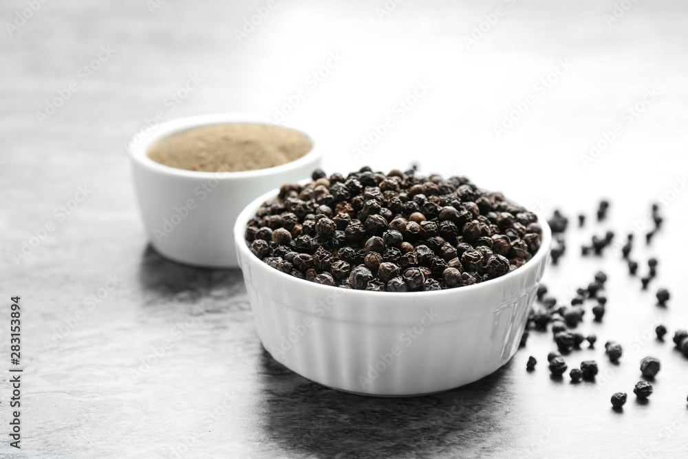 Ground black pepper and corns on grey table Ground black pepper and corns on grey table