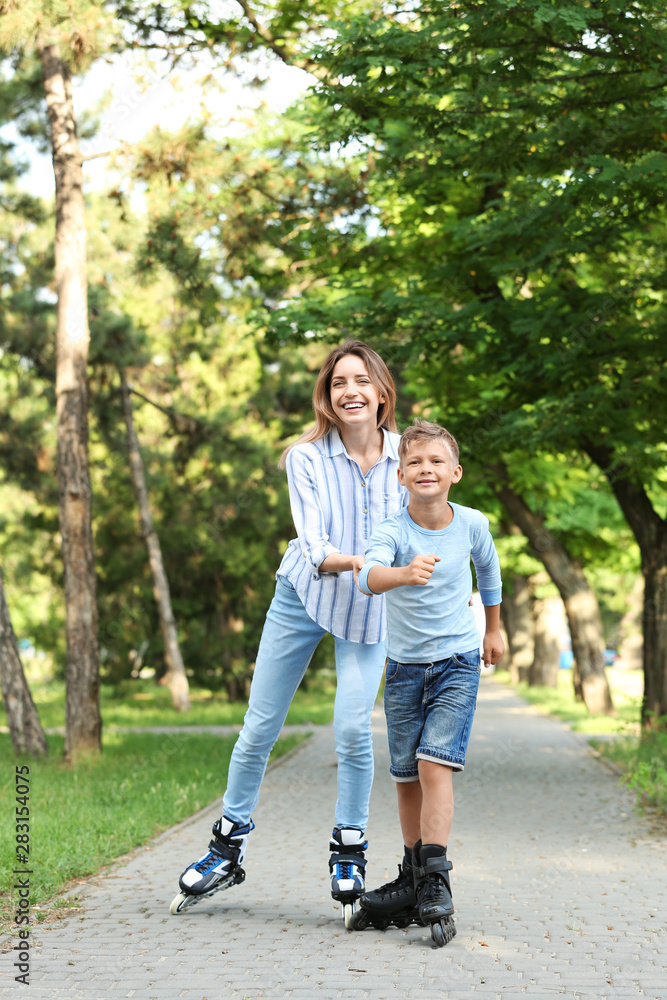 Mother and son roller skating in summer park Mother and son roller skating in summer park