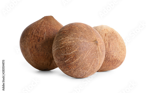 Ripe whole brown coconuts on white background
