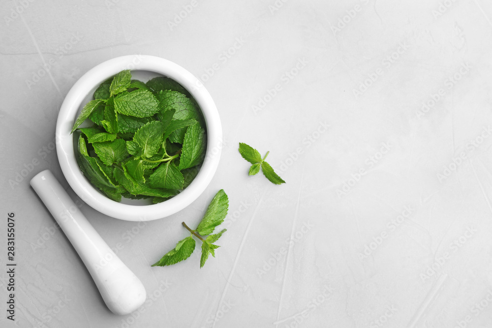 Fresh mint with mortar and pestle on grey background, flat lay. Space for text - obrazy, fototapety, plakaty 