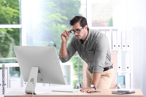 Handsome young man working with computer in office