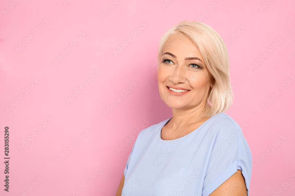 Fototapeta premium Portrait of mature woman with beautiful face on pink background. Space for text