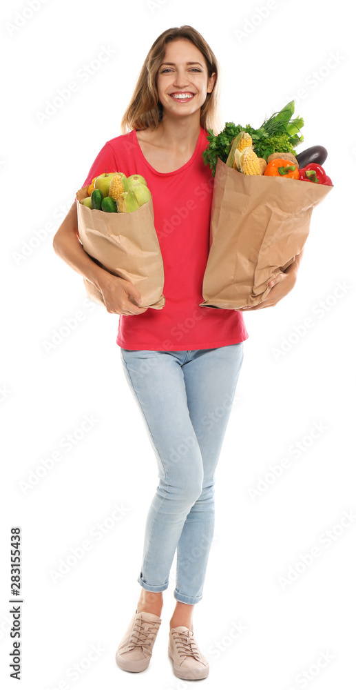 Young woman with bags of fresh vegetables isolated on white Young woman with bags of fresh vegetables isolated on white