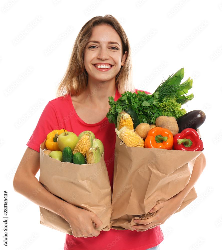 Young woman with bags of fresh vegetables isolated on white Young woman with bags of fresh vegetables isolated on white