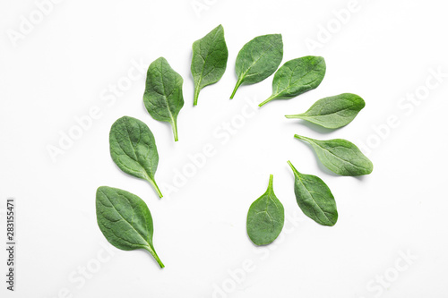 Frame made of fresh green healthy spinach leaves on white background, top view
