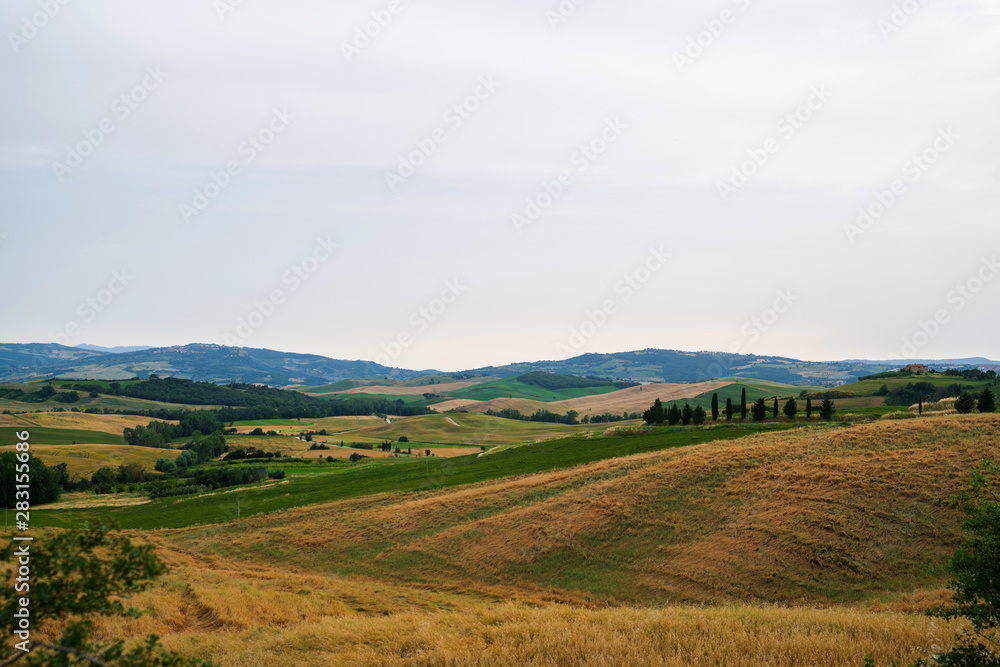 Majestic view of typical Tuscany countryside nature landscape. Beautiful hills at the sunrise time, fields and rural road. Italy, Europe. Holiday, traveling concept. Majestic view of typical Tuscany countryside nature landscape. Beautiful hills at the sunrise time, fields and rural road. Italy, Europe. Holiday, traveling concept.