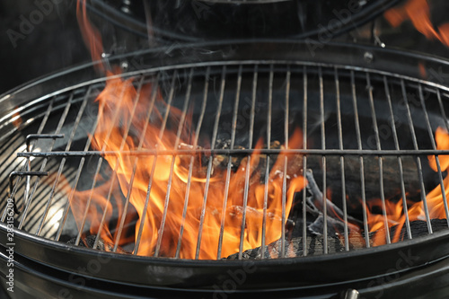 New modern barbecue grill with burning firewood, closeup