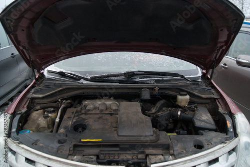 Dusty car gasoline engine. Powerful 4x4 car motor. Open car hood with engine inside.